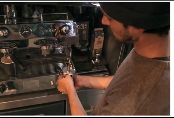 Barista trækker en espresso på maskinen