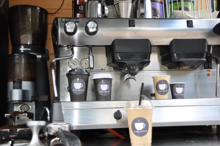 Espressomaskine og kaffekopper med The Little Coffee Break-logo