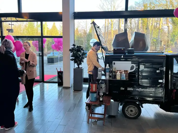 Kaffevogn indendørs til firmaevent med gæster og balloner